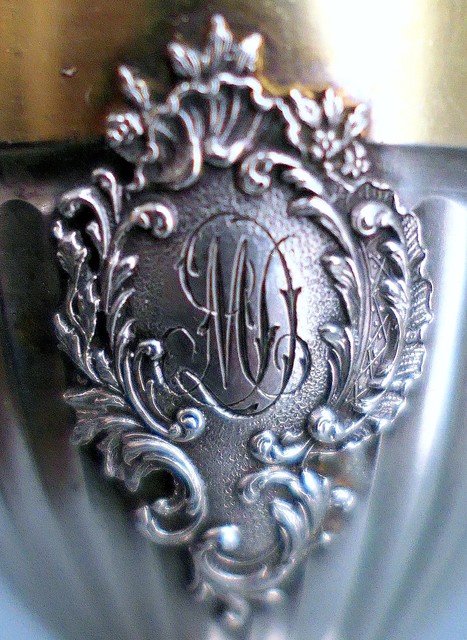 Applied rococo crest with cursive cypher "DM"