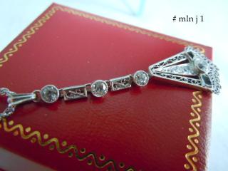 Three diamonds in tube collets alternate two rectangular- framed filigree links.